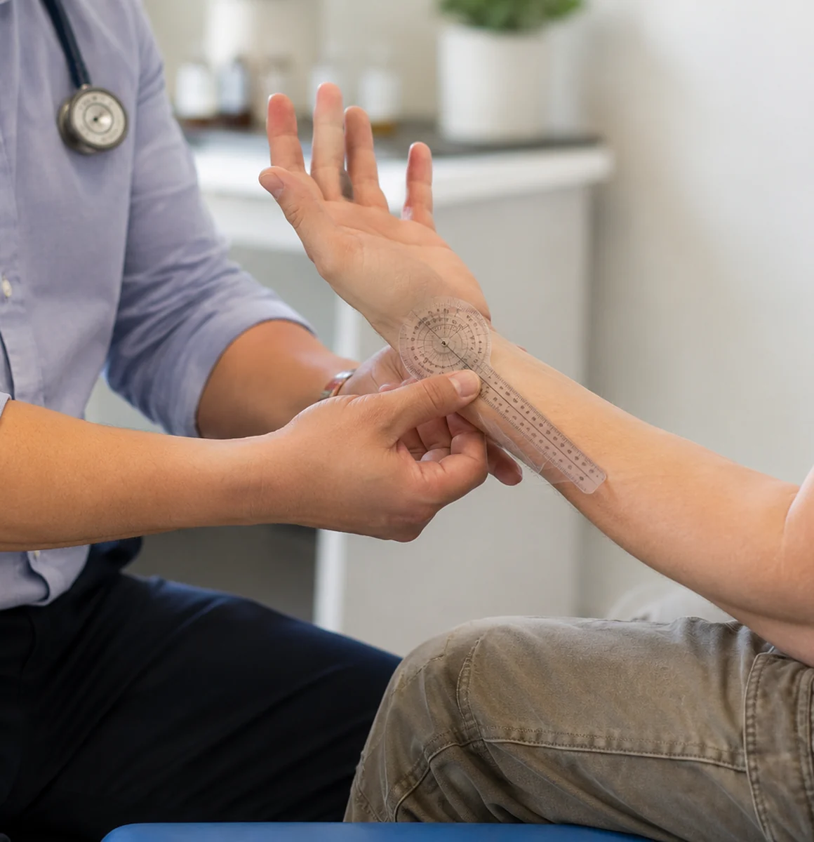 Occupational medicine physician measuring wrist range of motion during an impairment rating examination