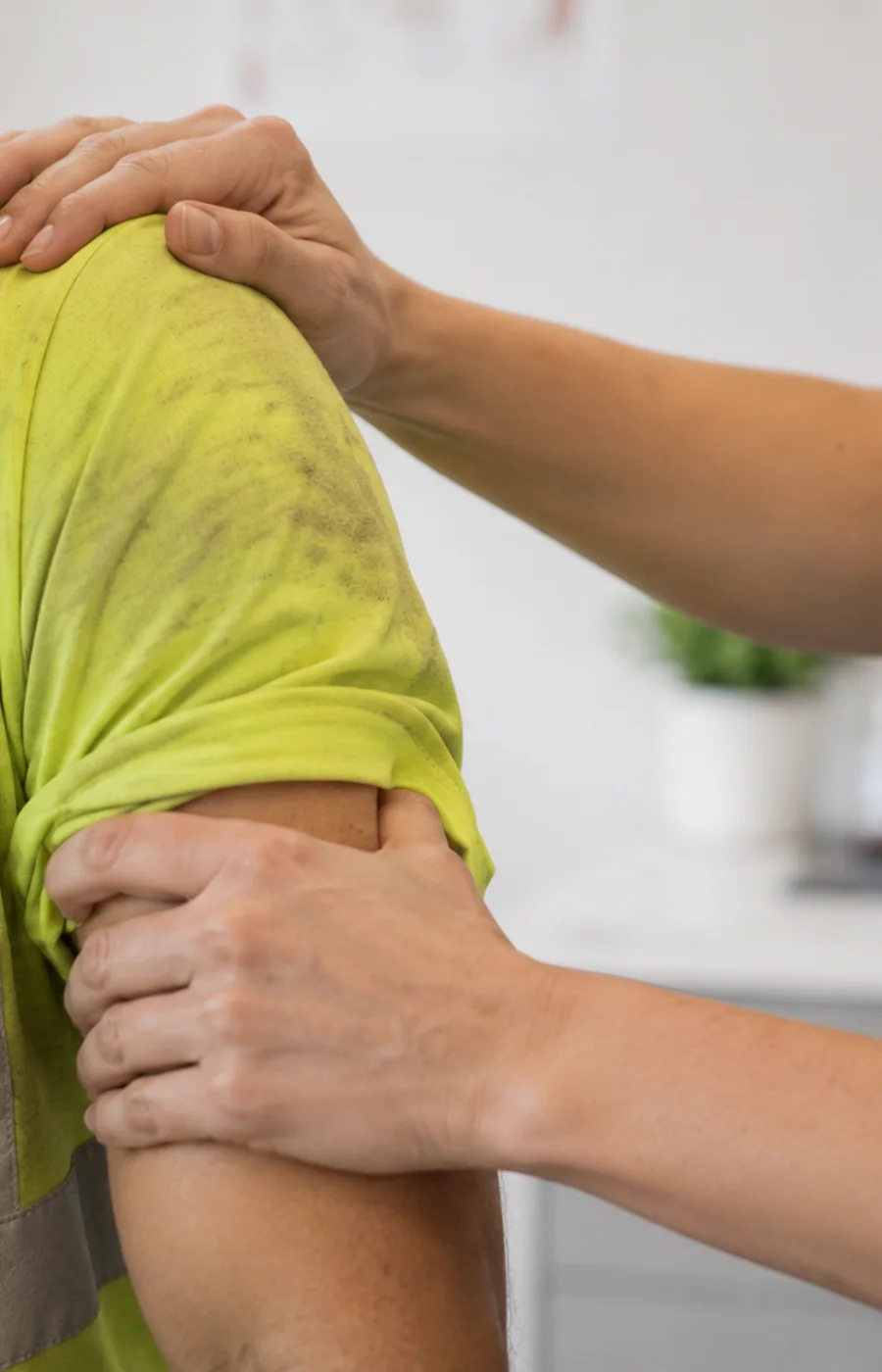 Clinician examining an injured worker's shoulder at a Work Well Clinics occupational medicine visit